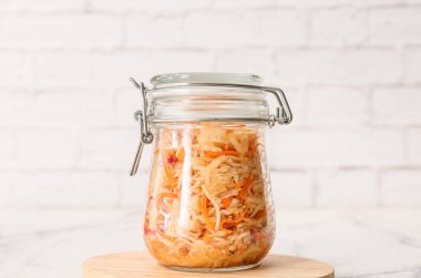 Hafif arka planda lezzetli lahana turşusu olan cam kavanoz.