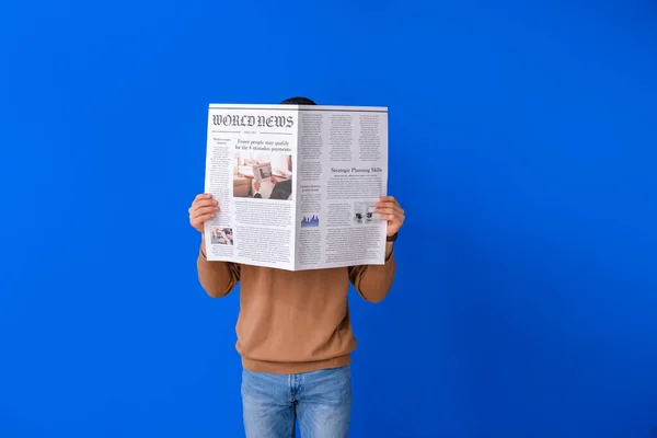 Junger Mann Liest Zeitung Auf Farbigem Hintergrund — Stockfoto