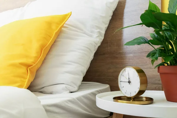 寝室のテーブルの上の目覚まし時計と観葉植物 — ストック写真
