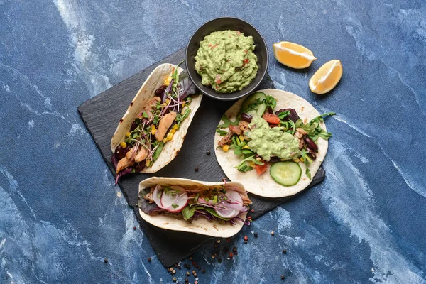 Tafel Mit Tacos Und Leckerem Guacamole Schale Auf Farbigem Hintergrund — Stockfoto