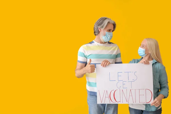 シニアカップルホールドポスターでテキストLet Get Vaccinated Color Background — ストック写真