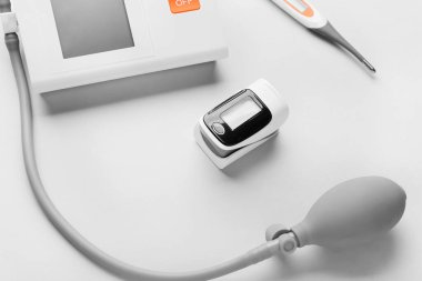 Işık arkaplanındaki sfenometre ve termometreyle nabız oksimetresi