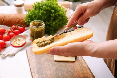 Kadın mutfakta lezzetli bir sandviç hazırlıyor.