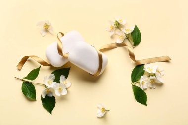 Renkli arkaplanda sabun çubukları, kurdele ve çiçeklerle kompozisyon