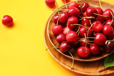 Renkli arka planda lezzetli olgun kirazlı kase, yakın plan.