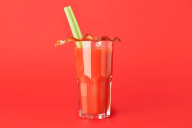 Arka planda pastırmayla süslenmiş bir bardak Bloody Mary kokteyli