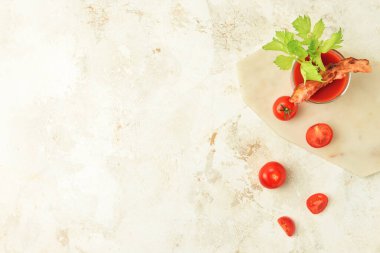 Domuz pastırması ve domateslerle süslenmiş bir bardak Bloody Mary kokteyli.