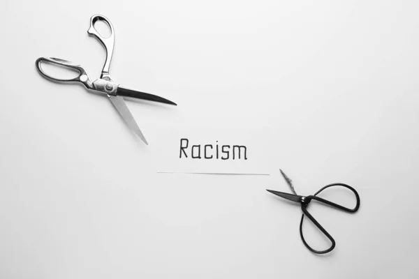 Χαρτί Λέξη Racism Και Ψαλίδι Λευκό Φόντο — Φωτογραφία Αρχείου