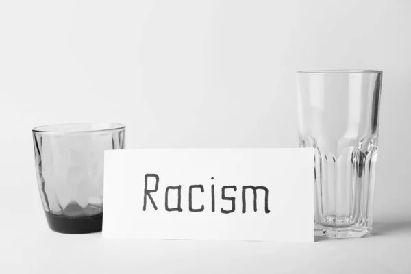 白い背景に単語Racismと眼鏡と紙の作品 — ストック写真