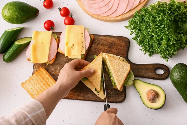 Vrouw Snijden Smakelijke Sandwich Lichte Achtergrond — Stockfoto