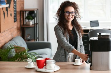 Güzel genç bayan mutfakta kahve yapıyor.