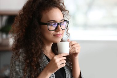 Güzel genç bayan mutfakta kahve içiyor.