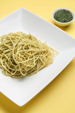 Renkli arkaplanda lezzetli pesto makarna tabağı