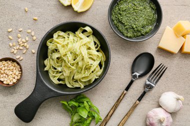 Gri arka planda pesto soslu lezzetli makarna.