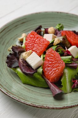 Hafif ahşap arka planda lezzetli greyfurt salatası, yakın plan.