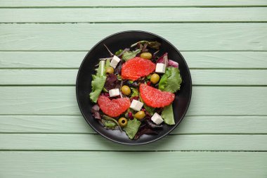 Renkli ahşap arka planda lezzetli greyfurt salatası tabağı