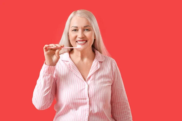 Reife Frau Beim Zähneputzen Auf Farbigem Hintergrund — Stockfoto