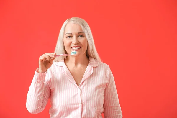 Reife Frau Beim Zähneputzen Auf Farbigem Hintergrund — Stockfoto