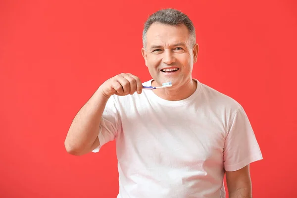 Mature Man Brushing Teeth Color Background — Stock Photo, Image
