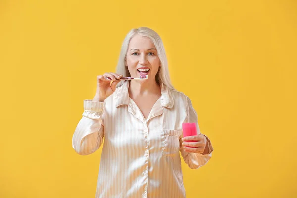 Reife Frau Beim Zähneputzen Auf Farbigem Hintergrund — Stockfoto