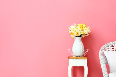 Masada narsist çiçekleri olan vazo.