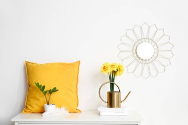 Narkissus çiçekleri, yastık ve kitaplarla dolu bir teneke kutu.