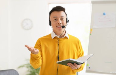 Sınıfta Asyalı öğretmen çevrimiçi ders veriyor.