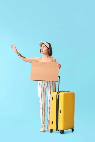 Mujer Joven Con Cartulina Maleta Haciendo Autostop Sobre Fondo Color — Foto de Stock