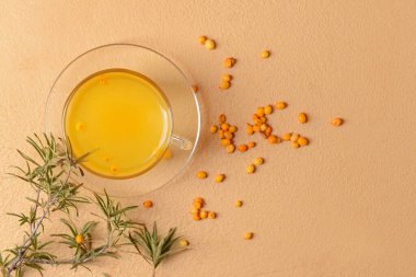 Arka planda bir bardak sağlıklı deniz dikenli çay.