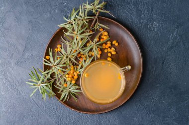 Koyu arkaplanda bir bardak sağlıklı deniz dikenli çay.