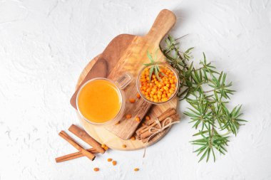 Beyaz arka planda bir bardak sağlıklı deniz dikenli çay.