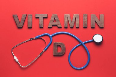 Renk arkaplanında steteskop bulunan metin VITAMIN D
