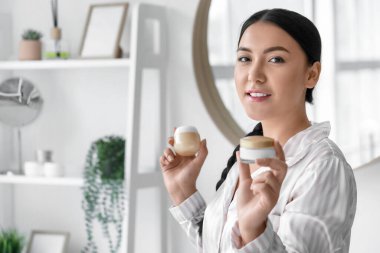 Banyoda kremalı güzel bir Asyalı kadın.