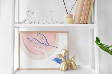 Dekorlu kitap rafı ve ışık duvarının yanındaki resim.