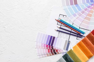 Beyaz arkaplanda boya rengi paletleri ve kumaş örnekleriyle bileşim