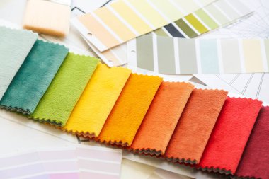 Açık arkaplanda boya rengi paletleri ve kumaş örnekleriyle bileşim