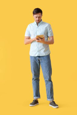 Arkaplanda tablet bilgisayar kullanan yakışıklı adam