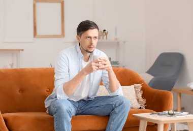 Evde çay içen yakışıklı adam.