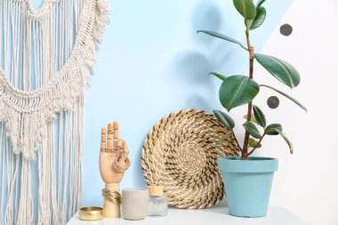 Renk duvarının yanındaki rafta şık aksesuarları olan tahta bir el.