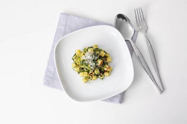 Beyaz arka planda lezzetli makarna ve ıspanak tabağı.