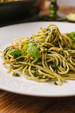 Masada lezzetli makarna ve ıspanak tabağı, yakın plan.