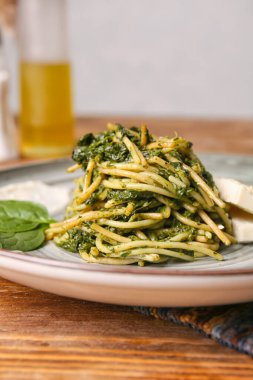 Masada lezzetli makarna ve ıspanak tabağı, yakın plan.