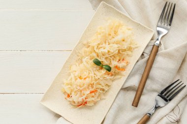 Hafif ahşap masada lezzetli lahana turşusu tabağı.