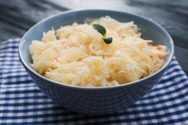 Koyu ahşap arka planda lezzetli lahana turşusu ile kase