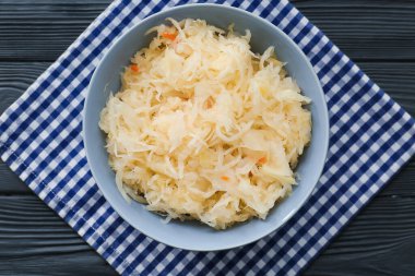 Koyu ahşap arka planda lezzetli lahana turşusu ile kase