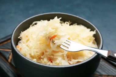 Koyu arkaplanda lezzetli lahana turşusu olan bir kase