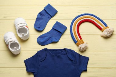 Renkli tahta arka planda bebek kıyafetleri.