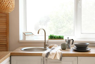 Büyük pencereli modern mutfağın içi.