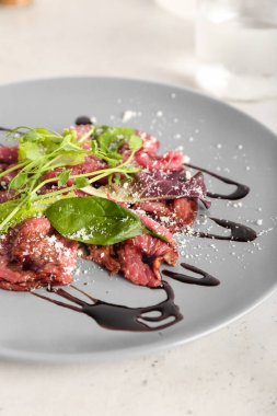 Hafif arka planda lezzetli dana etli carpaccio.