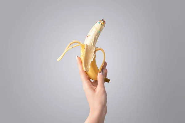 Mano Femenina Con Plátano Salpicaduras Sobre Fondo Gris Concepto Erótico — Foto de Stock